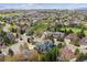 Expansive aerial shot showcases a home and the surrounding neighborhood with lush landscaping, against mountain views at 10029 Winterthur Ct, Highlands Ranch, CO 80129