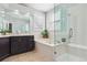 Bright bathroom featuring a soaking tub, glass-enclosed shower, and vanity with a dark wood finish at 10029 Winterthur Ct, Highlands Ranch, CO 80129