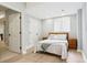 Bedroom features a bed with soft bedding, wooden nightstands, and a door to the hallway at 10029 Winterthur Ct, Highlands Ranch, CO 80129