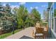 Spacious deck features wood flooring, metal railings, and beautiful views of the surrounding landscape and lush trees at 10029 Winterthur Ct, Highlands Ranch, CO 80129