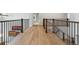 Upstairs hallway featuring wood floors, wood and wrought iron railings, and views to downstairs at 10029 Winterthur Ct, Highlands Ranch, CO 80129