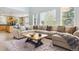 Bright and airy living room with a large sectional sofa, hardwood floors, an oversized area rug, and natural light at 10029 Winterthur Ct, Highlands Ranch, CO 80129