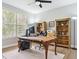 Cozy home office with hardwood floors features large windows, built-in bookshelves, and a comfortable chair at 10029 Winterthur Ct, Highlands Ranch, CO 80129