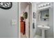 Powder room with a pedestal sink, light blue walls, and decorative mirror and lighting at 9571 Marmot Ridge Cir, Littleton, CO 80125