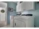 This laundry room features a washer, dryer, and white cabinets for optimal home convenience at 9571 Marmot Ridge Cir, Littleton, CO 80125