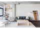 Bright living room boasts modern decor, concrete pillar and ductwork, and city views from a large window at 2100 16Th St # 405, Denver, CO 80202