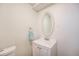 This bathroom includes a sink with vanity, toilet, mirror, and natural light at 12323 W Connecticut Dr, Lakewood, CO 80228