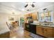 Bright kitchen with wooden cabinetry, black appliances, and a dining area with a sliding glass door at 12323 W Connecticut Dr, Lakewood, CO 80228