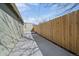 Narrow backyard featuring a tall, newly installed fence, blue skies and little landscaping at 3420 Julian St, Denver, CO 80211