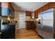 Modern kitchen with stainless steel refrigerator, dark countertops and wood cabinets at 3420 Julian St, Denver, CO 80211