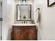 Charming powder room featuring a vanity with marble countertop and decorative mirror at 10158 Granby St, Commerce City, CO 80022