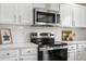 Well-equipped kitchen with stainless steel appliances, white cabinets, and subway tile backsplash at 10158 Granby St, Commerce City, CO 80022