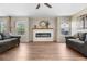 Cozy living room with wood floors, a modern fireplace, and large windows offering natural light at 10158 Granby St, Commerce City, CO 80022