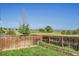 A fenced backyard has a green lawn, garden bed, and beautiful views of mountains and open space at 10521 Taylor Ave, Firestone, CO 80504