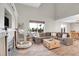 Spacious living room with high ceilings, wood floors, large windows, and a stone fireplace at 10521 Taylor Ave, Firestone, CO 80504