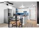 Well-lit kitchen features stainless steel appliances, a dining table, and stylish white cabinetry at 1121 Albion St # 210, Denver, CO 80220