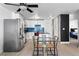 Open kitchen area with stainless steel appliances, white cabinets, and a dining table set for two at 1121 Albion St # 210, Denver, CO 80220