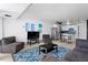 Open-concept living room and kitchen with stainless steel appliances, modern décor, and hardwood floors at 1121 Albion St # 210, Denver, CO 80220