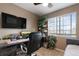 Bedroom with a desk, wall-mounted TV, daybed, and large window, offering a versatile and comfortable living space at 4231 S Quemoy Ct, Aurora, CO 80018