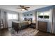 A well-lit bedroom with a ceiling fan, windows, and a wood-framed bed at 519 Wright St # 108, Lakewood, CO 80228