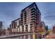Exterior shot of a modern building featuring balconies, glass windows, and street view, showcasing the building's architecture at 1401 Wewatta St # 308, Denver, CO 80202