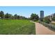 Expansive green space with walking paths, mature trees, and a modern high-rise building in the backdrop at 1401 Wewatta St # 308, Denver, CO 80202