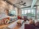 Living room featuring a comfortable leather sofa, brick accents, and a large window overlooking the city at 1401 Wewatta St # 308, Denver, CO 80202