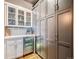 Butler's pantry with beverage cooler, display cabinets, and ample cabinet storage at 1401 Wewatta St # 308, Denver, CO 80202