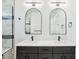 Modern bathroom featuring double sinks, arched mirrors, and a walk-in shower at 3226 W Dakota Ave, Denver, CO 80219