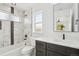 Beautiful bathroom featuring marble tiling, a bathtub and shower, and a dark vanity at 3226 W Dakota Ave, Denver, CO 80219