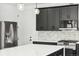 Modern kitchen featuring a stainless steel refrigerator, dark cabinets, and marbled backsplash and counters at 3226 W Dakota Ave, Denver, CO 80219