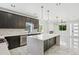 Elegant kitchen featuring a large island, dark cabinets, marble counters and floors at 3226 W Dakota Ave, Denver, CO 80219