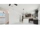 Modern kitchen with a center island, dark cabinetry, and marble flooring at 3226 W Dakota Ave, Denver, CO 80219