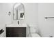 Stylish powder room with a dark vanity, modern fixtures, and an arched mirror at 3226 W Dakota Ave, Denver, CO 80219