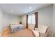 This bedroom offers a cozy retreat with soft lighting, warm tones, and a comfortable armchair at 14833 Vine St, Thornton, CO 80602