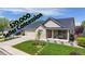 Charming brick home featuring a covered front porch, manicured lawn, and a two-car garage at 14833 Vine St, Thornton, CO 80602