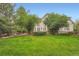 Manicured lawn surrounding an elegant home with mature trees and rock features at 22019 E Arbor Dr, Aurora, CO 80016