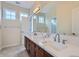 Bright bathroom featuring dual sinks, a large mirror, and modern fixtures at 22019 E Arbor Dr, Aurora, CO 80016