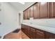 Functional laundry room featuring ample counter space, abundant cabinetry and wood-look tile flooring at 22019 E Arbor Dr, Aurora, CO 80016