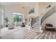 Spacious living room with large windows, a staircase, and comfortable seating and sleek flooring at 22019 E Arbor Dr, Aurora, CO 80016