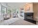 Cozy sitting room with fireplace, built-in shelves, and comfortable seating with sunlit bay windows at 22019 E Arbor Dr, Aurora, CO 80016