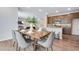 Open concept dining area features a wood table, seating for six, and adjacent kitchen with modern countertops and cabinets at 9972 Wheeling St, Commerce City, CO 80022