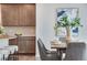 Open concept dining room showcasing a wood table, seating for six, modern decor, and an adjacent kitchen with modern appliances at 9972 Wheeling St, Commerce City, CO 80022