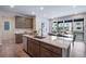 Modern open kitchen featuring an island with a sink, cabinetry, and adjacent dining area at 9972 Wheeling St, Commerce City, CO 80022