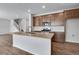 Modern kitchen with a large island, stainless steel appliances, and wood-look flooring at 9972 Wheeling St, Commerce City, CO 80022