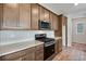 Modern kitchen with stainless steel appliances and wood cabinets at 9972 Wheeling St, Commerce City, CO 80022