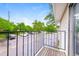 A balcony overlooking a well-maintained parking lot, lush green trees and clear blue sky at 9005 E Lehigh Ave # 16, Denver, CO 80237