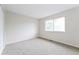 A bright bedroom featuring a neutral color scheme and carpeted floor with a window overlooking the outdoors at 9005 E Lehigh Ave # 16, Denver, CO 80237