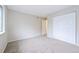 A bedroom is bright with neutral paint, plush carpet, and has a door leading to the bathroom at 9005 E Lehigh Ave # 16, Denver, CO 80237