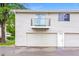 View of the exterior of a home featuring a balcony above a garage and secondary door at 9005 E Lehigh Ave # 16, Denver, CO 80237